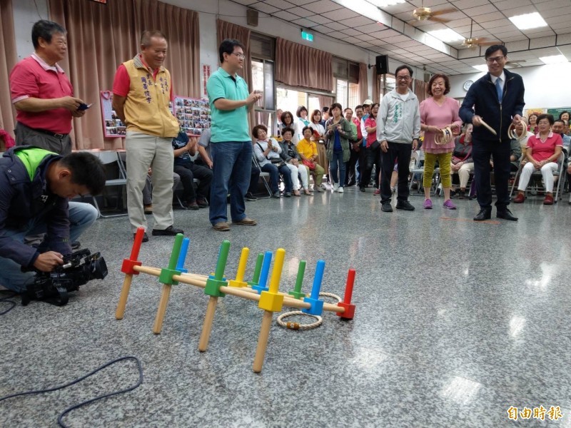 行政院副院長陳其邁（右1）今由立委李昆澤（右3）陪同訪視三民區安宜里關懷據點，與長輩一起玩「賓果投擲」遊戲，沒想到被長輩「電甲金熠熠」。（記者方志賢攝）