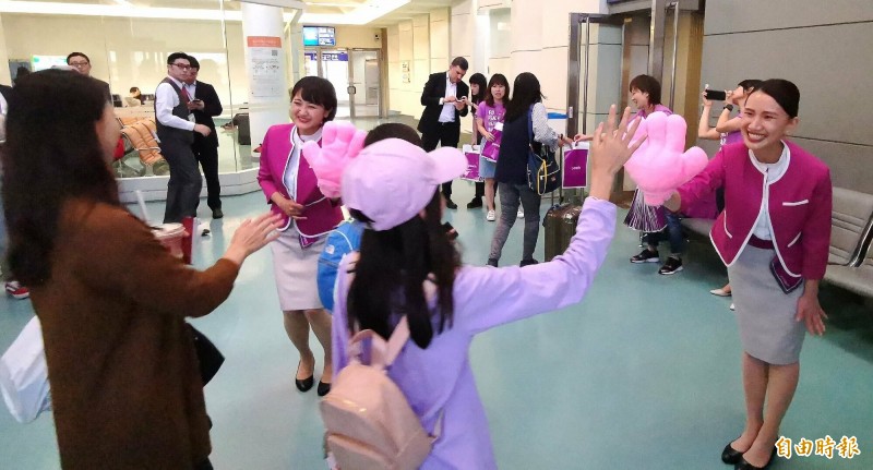 日本樂桃航空24日開闢福岡航線，這也是樂桃在台灣開闢的第10條航線，為了慶祝首航，樂桃推出1580元優惠機票。下午4時30分首航班機開始登機，搭機旅客在空橋門口與地勤人員「擊掌」慶祝。（記者姚介修攝）