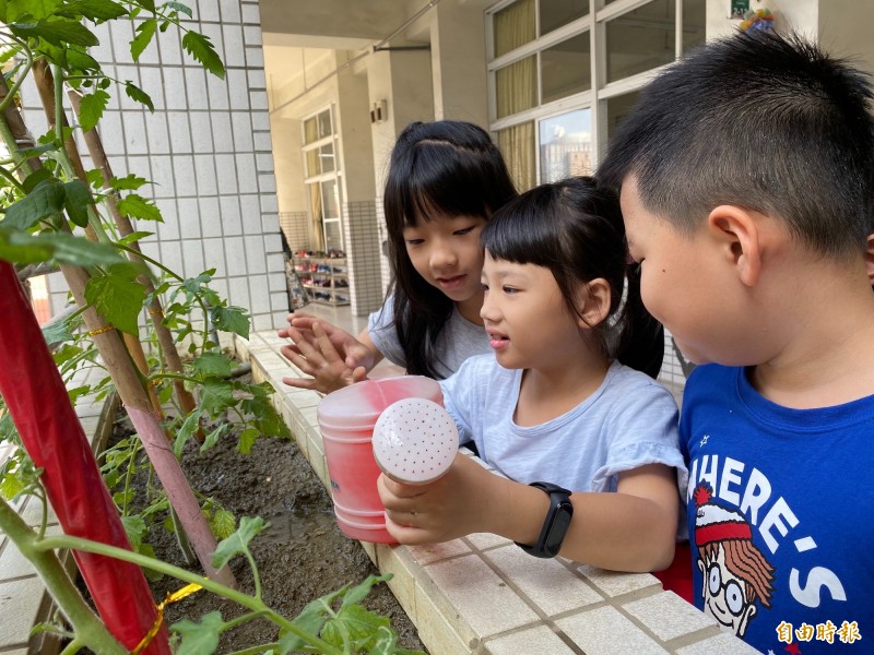 學童為陽台作物澆水。（記者黃旭磊攝）