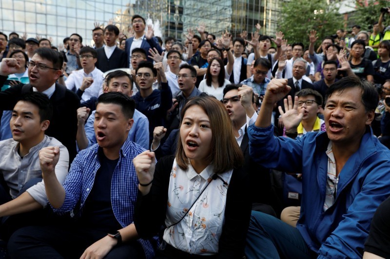 香港區議會選舉昨順利落幕，泛民主派大勝，近60名民主派當選人25日下午到香港理工大學附近聚集，聲援理大內的被困人士，要求港府下令警方撤離現場。（路透）