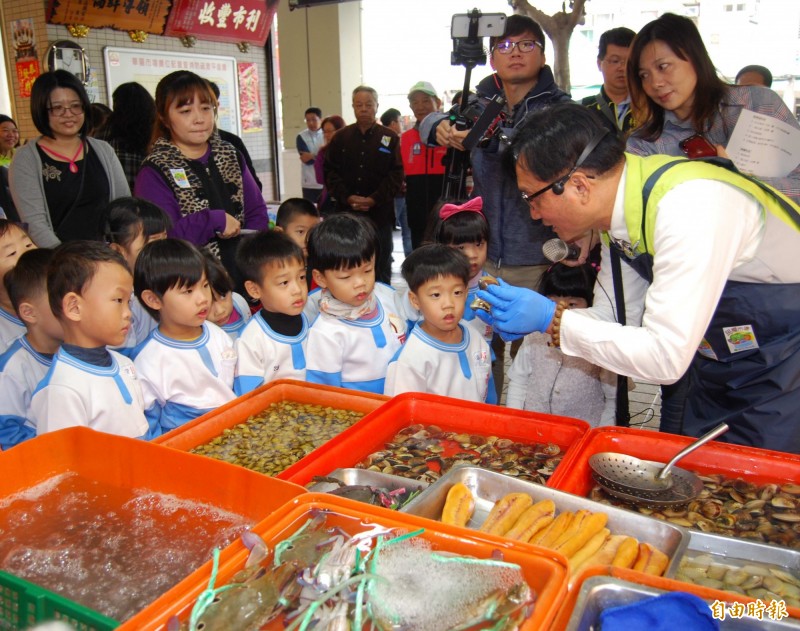 彰化市長林世賢（右）在華陽市場直播教導小朋友如何辨識海產的新鮮度。（記者湯世名攝）