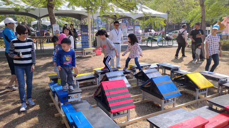 中山大學舉辦「街頭玩童─鹽埕兒童街頭遊戲日」活動，運用廢棄課桌椅、輪胎及紙箱等素材，打造迷宮、紙飛機、機器人及海盜船等具挑戰性的新穎遊具，讓兒童在街頭體驗創新玩法。

（中山大學提供）