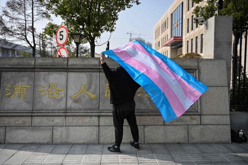 中國一位跨性別者楊小馬（化名）女士，以「平等就業權糾紛」狀告原雇主解雇違法，被視為多元性別族群（LGTBQ+）對中國性別平權所祭出的考驗。圖為楊女士在法院外舉起「跨性別旗」。（法新社）
