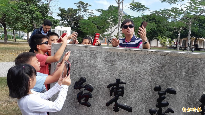 今天冬至，小朋友跟著李偉俊（右）以手機量測地球轉軸傾角。（記者黃明堂攝）