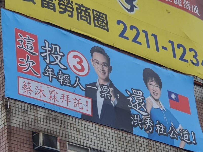 永和中正橋出現民進黨立委候選人蔡沐霖與前國民黨主席洪秀柱的「合體看板」，對手陣營林德福團隊向警方告發，檢警已介入偵辦。（記者陳薏云翻攝）