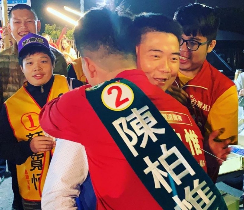 台中第二選區台灣基進立委候選人陳柏惟和國民黨立委候選人顏寬恒恰巧同時抵達台中龍津夜市拉票，雙方人馬相遇時也不忘展現風度，互相擁抱打氣，場面相當溫馨。（圖擷自陳柏惟臉書）
