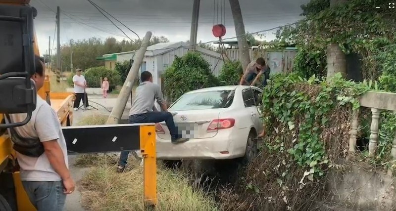 失控轎車飛過排水溝撞倒電桿及民宅圍牆。（台灣國際緊急救難總隊提供）