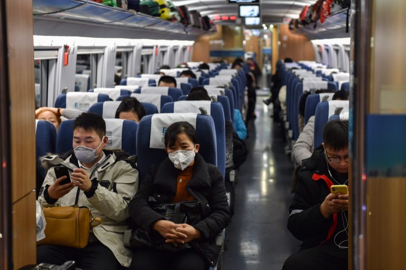 在高鐵上的乘客幾乎面掛口罩，以防武漢肺炎傳染。（法新社）