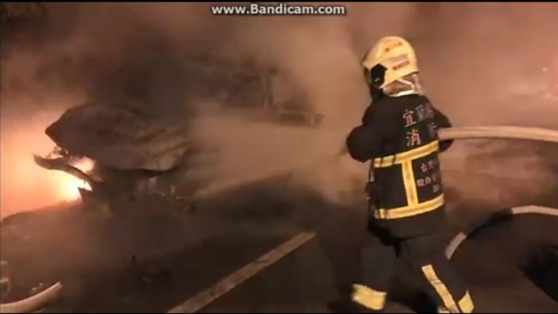 羅東鎮仁愛路三段今晚發生轎車撞機車後，又撞上橋墩起火燃燒，消防員到場射水滅火。（記者江志雄翻攝）