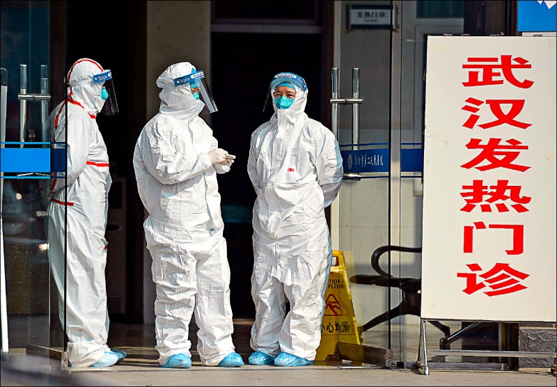 三名身穿防護服的醫護人員,站在中國阜陽市第二人民醫院的發燒門診外。(美聯社) 三名身穿防護服的醫護人員,站在中國阜陽市第二人民醫院的發燒門診外。(美聯社)
