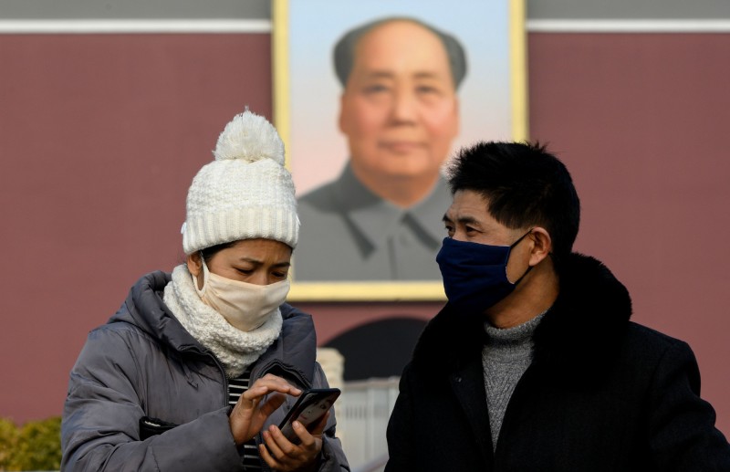 受武漢肺炎影響，緊鄰北京的天津市宣布學校與非必要公司全面延期開工。圖為中國民眾在北京天安門廣場戴著口罩。（法新社）