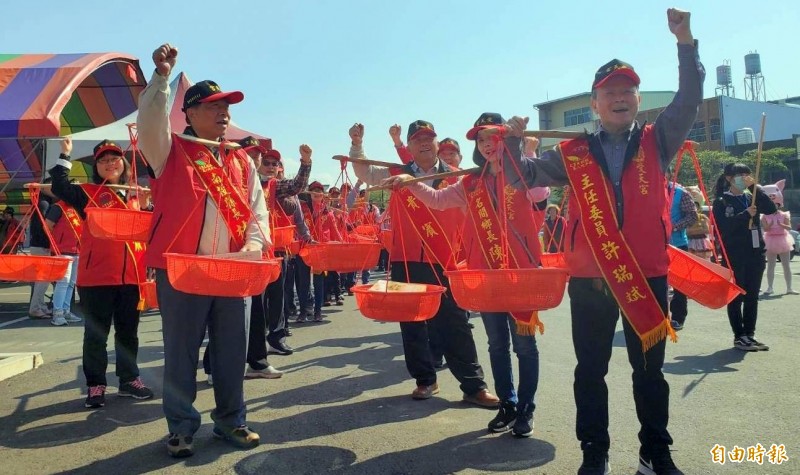 南投縣副縣長陳正昇（左）及受天宮主委許瑞斌（右）2人，也與民眾一起體驗挑米糕桃的樂趣。（記者謝介裕攝）