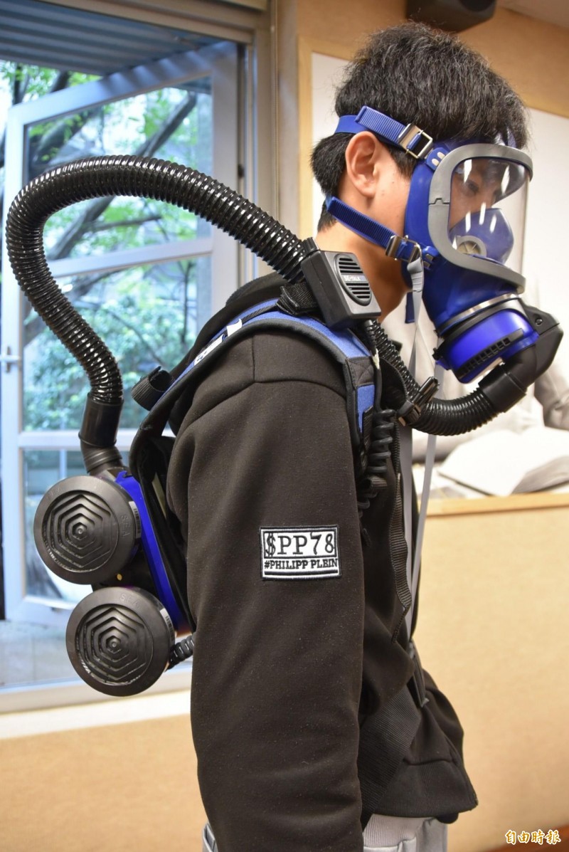 台大公衛學生示範PAPR動力空氣濾淨式呼吸防護用具，過去SARS期間，前台北市衛生局長邱淑媞曾經戴過。（記者吳柏軒攝）
