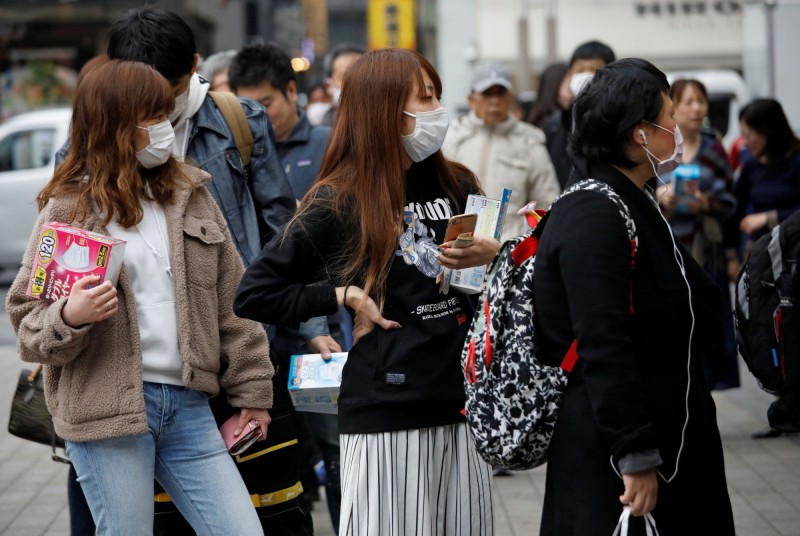 日本武漢肺炎疫情不停上升，東京民眾戴起口罩防疫。（路透）