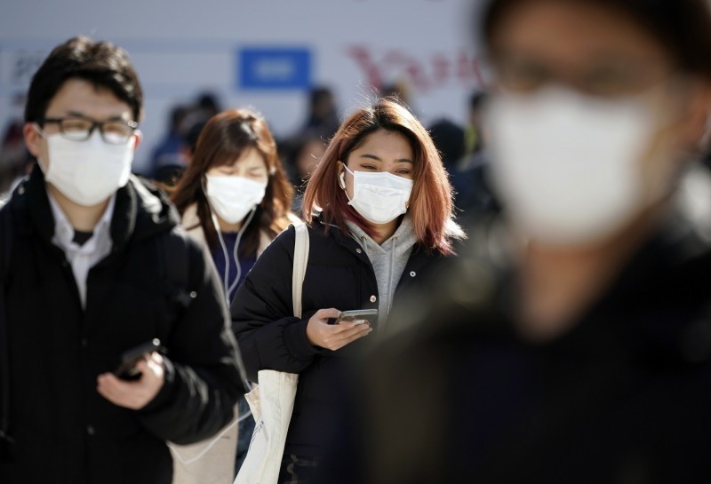 日本15日晚間再增一起武漢肺炎病例，是前例確診感染的60多歲男性患者的妻子。圖為日本街頭行人都戴著口罩。（歐新社）