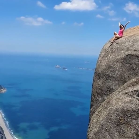 巴西里約熱內盧（Rio de Janeiro，簡稱里約）自然景點「桅帆岩」（Gávea Rock），因岩頂能俯瞰整座城市，不但深受旅客歡迎，也成為「打卡勝地」，卻出現許多旅客為了「照片效果」罔顧安全，直接坐在懸崖邊拍照、錄影，畫面驚險。（圖擷取自IG @gres_big_family）