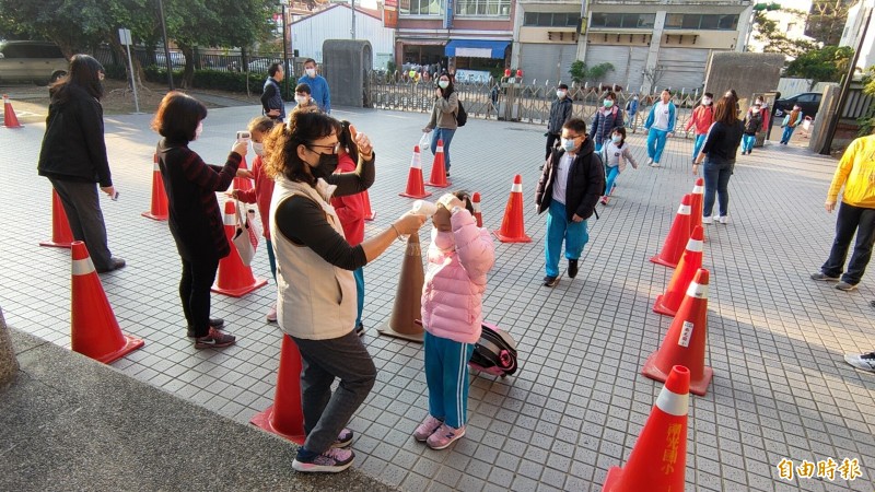 學生數有1300多人的南投縣埔里鎮南光國小，今天舉行全校返校日，防疫作戰提前登場，校方在校門口為每位學童量測額溫。（記者佟振國攝）