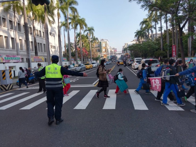 南市警一分局員警到轄區小學路口協助管制交通、護送學童平安上學。（記者王俊忠翻攝）