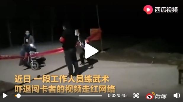 一名騎著車的男子意欲闖關，剛把車子停好，就挺著胸朝2個守著路口的防疫人員逼近，緊張的氣氛一觸即發。（圖擷取自微博）