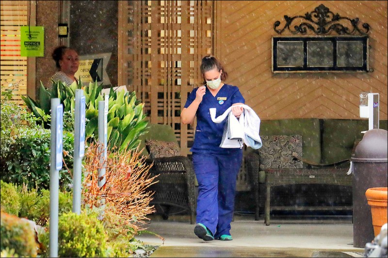 美國華盛頓州柯克蘭市「生活照護中心」再增四死，一名員工二日戴著口罩離開院區。（美聯社）