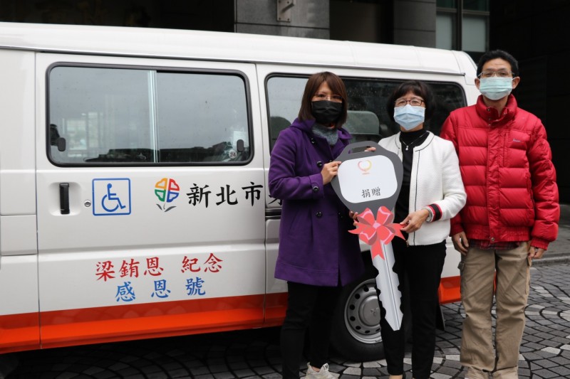 梁菀芸（左）在先生陪同下，將父親留下的遺產購買復康巴士捐給新北市政府，社會局副局長許秀能（中）代表受贈。（新北市政府社會局提供）