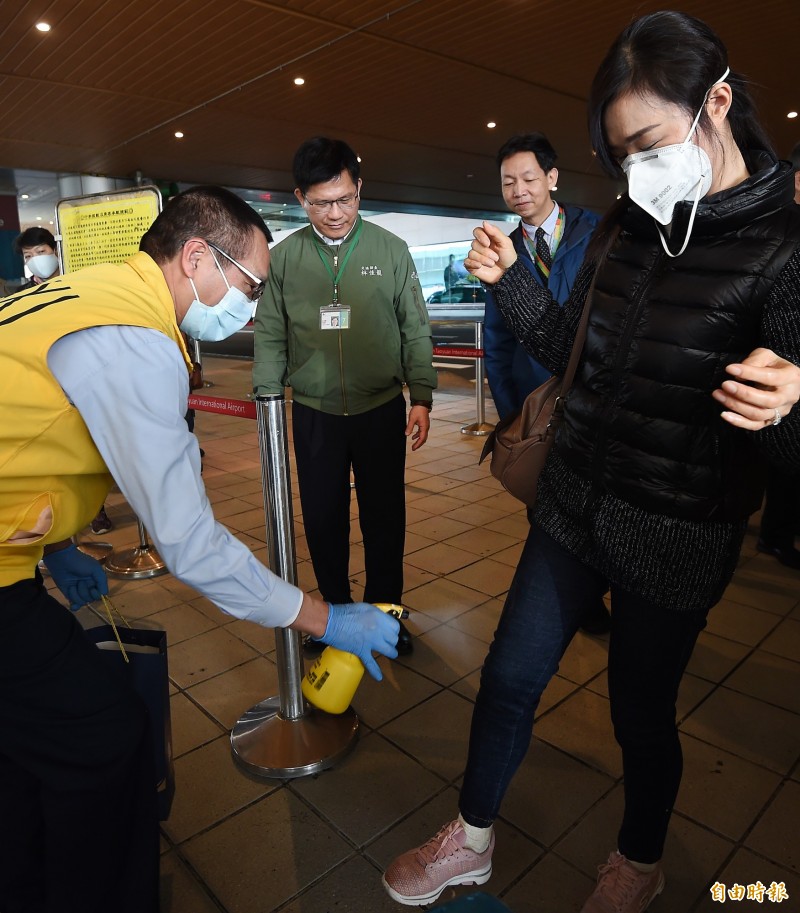 交通部長林佳龍（左二）7日前往桃園機場視察「防疫專車」接送旅客的各項流程與措施。圖為林佳龍視察防疫計程車為旅客消毒情形。（記者朱沛雄攝）