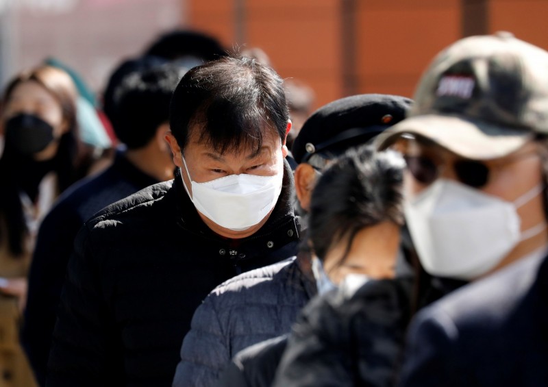 韓國藥局被納入口罩銷售網絡，但藥師們幾乎都是叫苦連天，因為他們不僅要注意有沒有人重複排隊，而且還要處理健保系統繁雜的口罩購買措施，最後整天下來只能賣口罩，完全是在孤軍奮戰。圖為南韓民眾排隊買口罩。（路透）