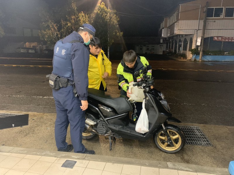 宋男（中）從花蓮掃墓回程機車沒油夜走10多公里，龍潭警幫買油解困。（記者李容萍翻攝）