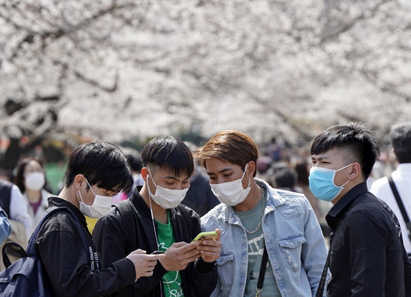 日本近期迎來櫻花季，儘管日本境內肺炎確診人數不斷增加，仍有不少民眾戴口罩出門賞櫻。（歐新社）

