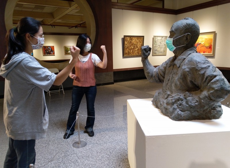 雕塑家李明憲創作《對付武漢病毒的勇者─陳時中》塑像，為這次抗疫的工作人員加油打氣，參觀民眾也跟著時中部長一起握拳加油。（港藝提供）