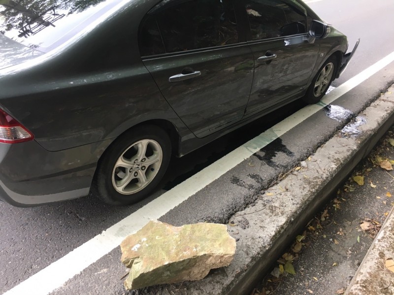 一輛轎車行經台廿一線新中橫公路，卻遭輪胎大的落石砸中車頭，所幸沒造成傷亡。（記者劉濱銓翻攝）