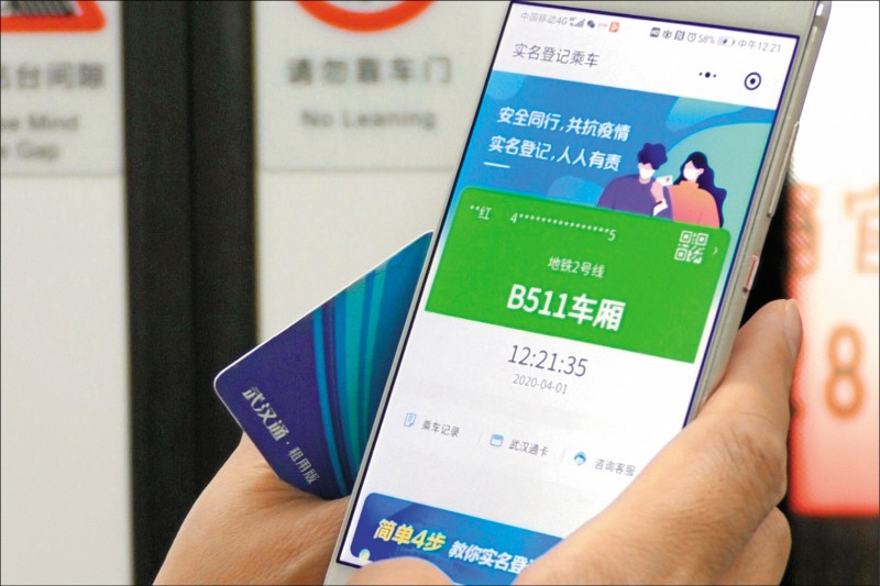 一名在中國湖北省武漢市搭乘地鐵的民眾，秀出其手機應用程式「健康碼」上的「綠碼」認證，代表他沒有出現武漢肺炎症狀。目前在武漢搭乘地鐵或進入旅館前，都必須出示以實名制登記的綠碼。（美聯社）
