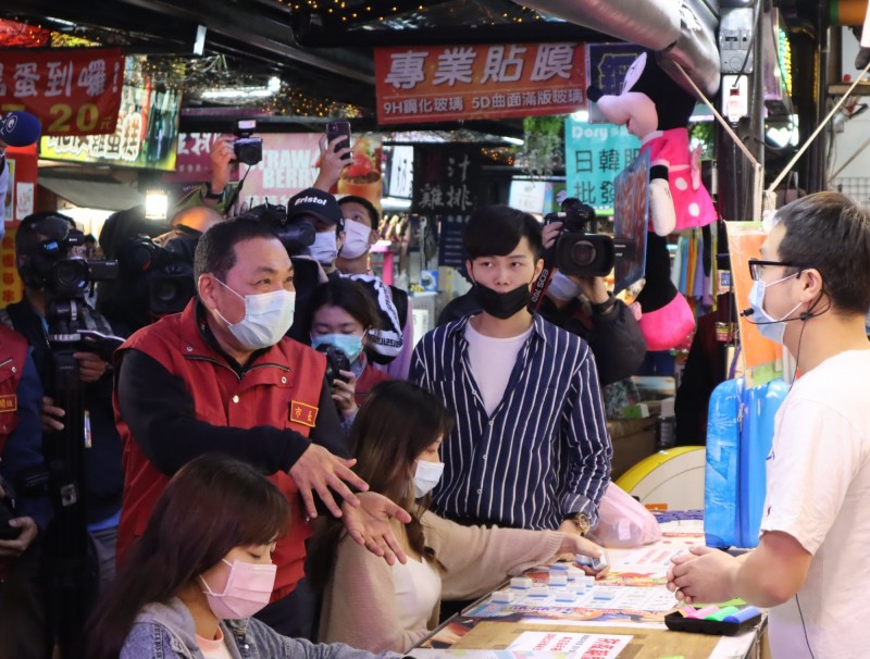 新北市長侯友宜於11日至樹林興仁花園夜市視察防疫作為，確認夜市出入口管制動線，並要求攤商、消費者落實配戴口罩。（圖由新北市場處提供）