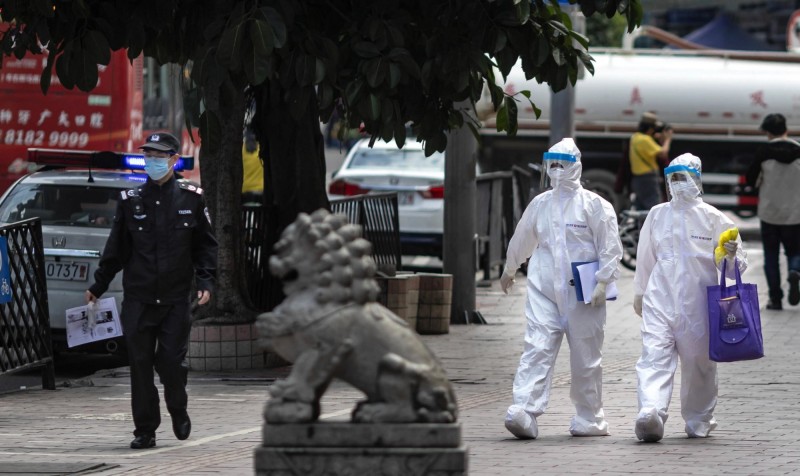 廣東每天固定新增3例確診，引爆中網質疑。圖為走在街道上的廣東警察與醫護人員。（歐新社）