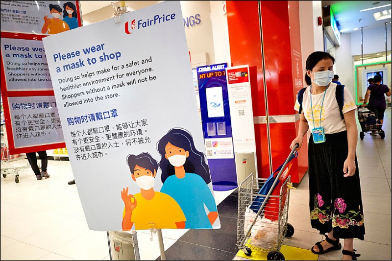 新加坡的武漢肺炎確診病例廿二日突破萬起，圖為當地一處購物商場內超級市場要求購物民眾戴口罩的宣導告示。
（歐新社）
