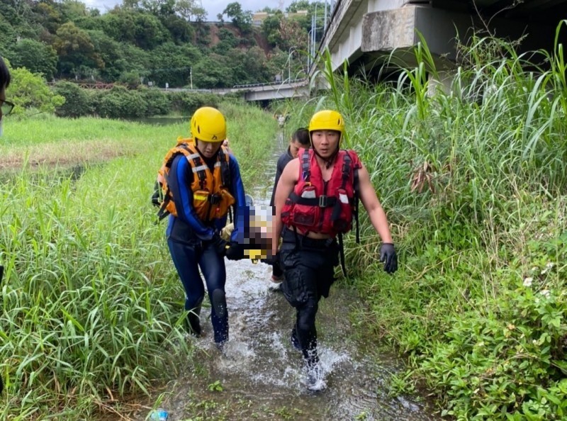 消防人員下水將溺水女性救援上岸送醫。（記者彭健禮翻攝）