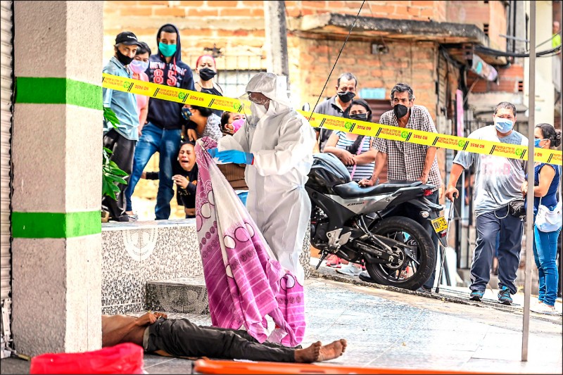 六日的南美洲哥倫比亞第二大城市麥德林（Medellin）街頭，身穿全套防護裝備的警察正在處理一名疑似死於武漢肺炎的男子屍體。截至七日，中南美洲已有超過一萬五千人死於武漢肺炎。（法新社）