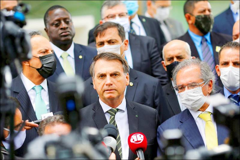 巴西總統波索納洛七日身旁高官與隨扈圍繞，在難以保持社交距離下，卻只有他沒戴口罩。（路透）