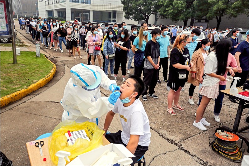 中國湖北省武漢市近日再度出現本土群聚感染，當局決定在十天內對全市一千一百萬人進行病毒核酸檢測，以揪出無症狀的感染者。圖為十五日民眾大排長龍接受檢測。（法新社）