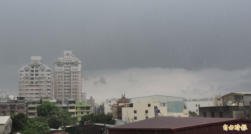 彰化市區上空蒙上一層烏雲，與遠處晴朗的天空形成「黑白分明」情景，不久之後市區就下起一陣大雨。（記者林良哲攝）