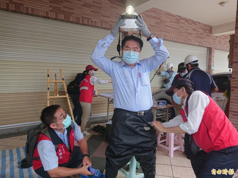 台南市長黃偉哲從下水道出來後，滿頭大汗，由工作人員協助卸裝。（記者洪瑞琴攝）