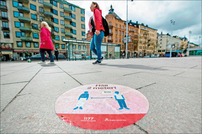 瑞典採行「佛系防疫」，並未實施有如歐洲各國的封鎖措施，僅敦促民眾遵守衛生與社交距離建議，並自我約束。圖為瑞典首都斯德哥爾摩市中心的大型道路貼紙，勸告民眾維持兩公尺安全距離。（法新社檔案照）