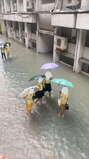 今天午後一場大雨，景美女中校園內淹水，學生涉水而過。（擷取自台大批踢踢）