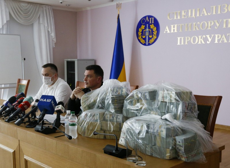 此案是烏克蘭史上最大的現金賄賂案，記者會現場擺滿了查獲的紙鈔。（美聯社）