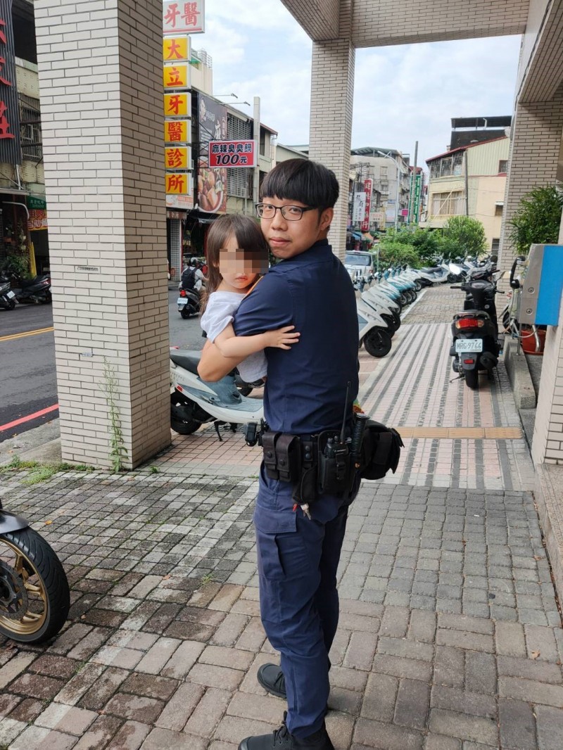 邱員公主抱小女童找到媽媽。（記者許國楨翻攝）