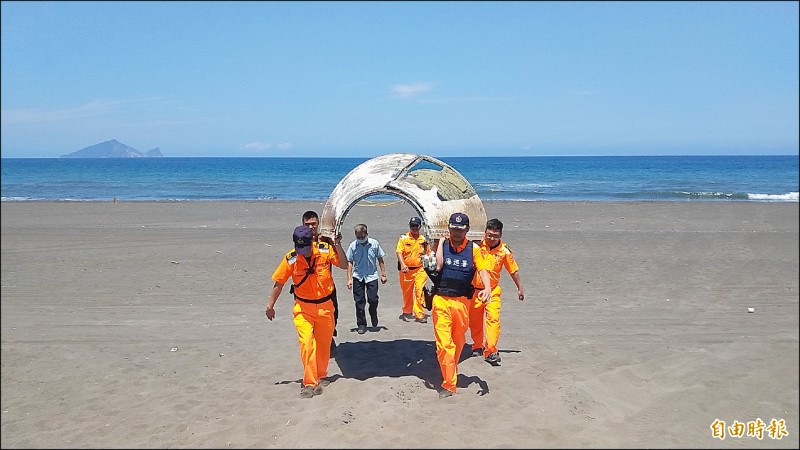 宜蘭壯圍永鎮海邊昨發現一塊大型殘骸，由海巡人員扛回安檢所。（記者張議晨攝）