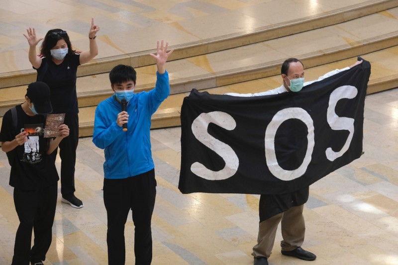 針對中國上月在兩會強行通過「港版國安法」，七大工業國集團（G7）成員國的外交部長發布聯合聲明，強烈呼籲中國重新考慮該項決定。圖為反對港版國安法的香港示威群眾手持有「SOS」標語的旗幟上街。（彭博）