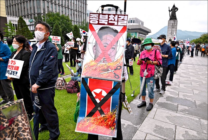 日本廿五日宣布取消部署用來防禦北韓攻擊的陸基神盾飛彈防禦系統。圖為一名男子廿五日拿著反北韓圖片出席南韓首爾的韓戰爆發七十週年集會。（法新社）