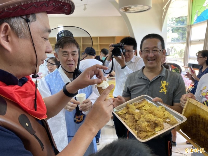 金門縣長楊鎮浯（左一）拿起冰過的蜂巢搭配冰淇淋嚐試新吃法。（記者吳正庭攝）