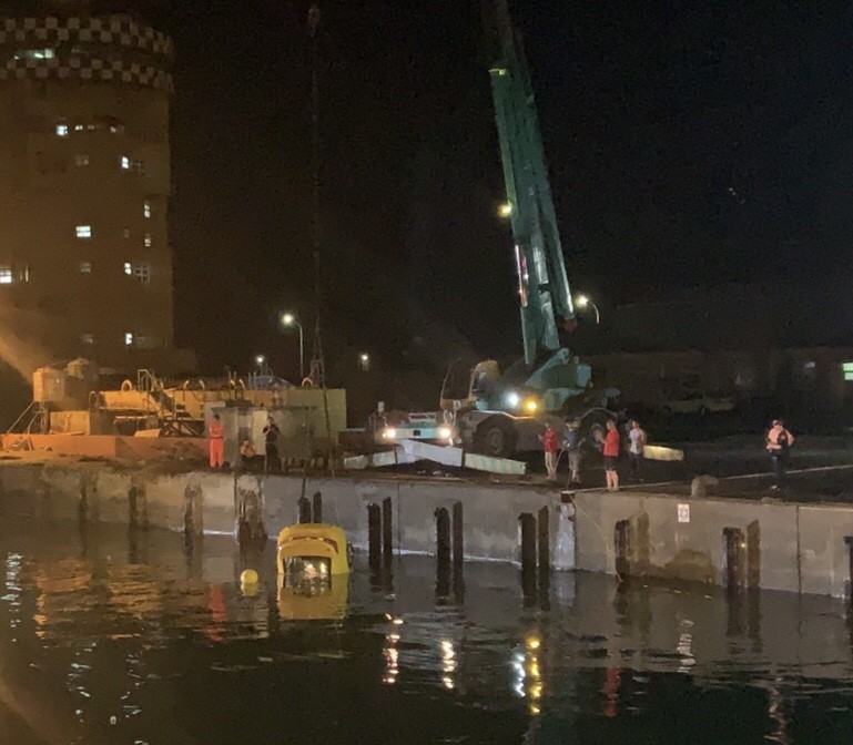 台中港務消防隊正派吊車，將落海的計程車吊起來。（記者歐素美翻攝）